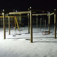 Deserted snowy playground at night.